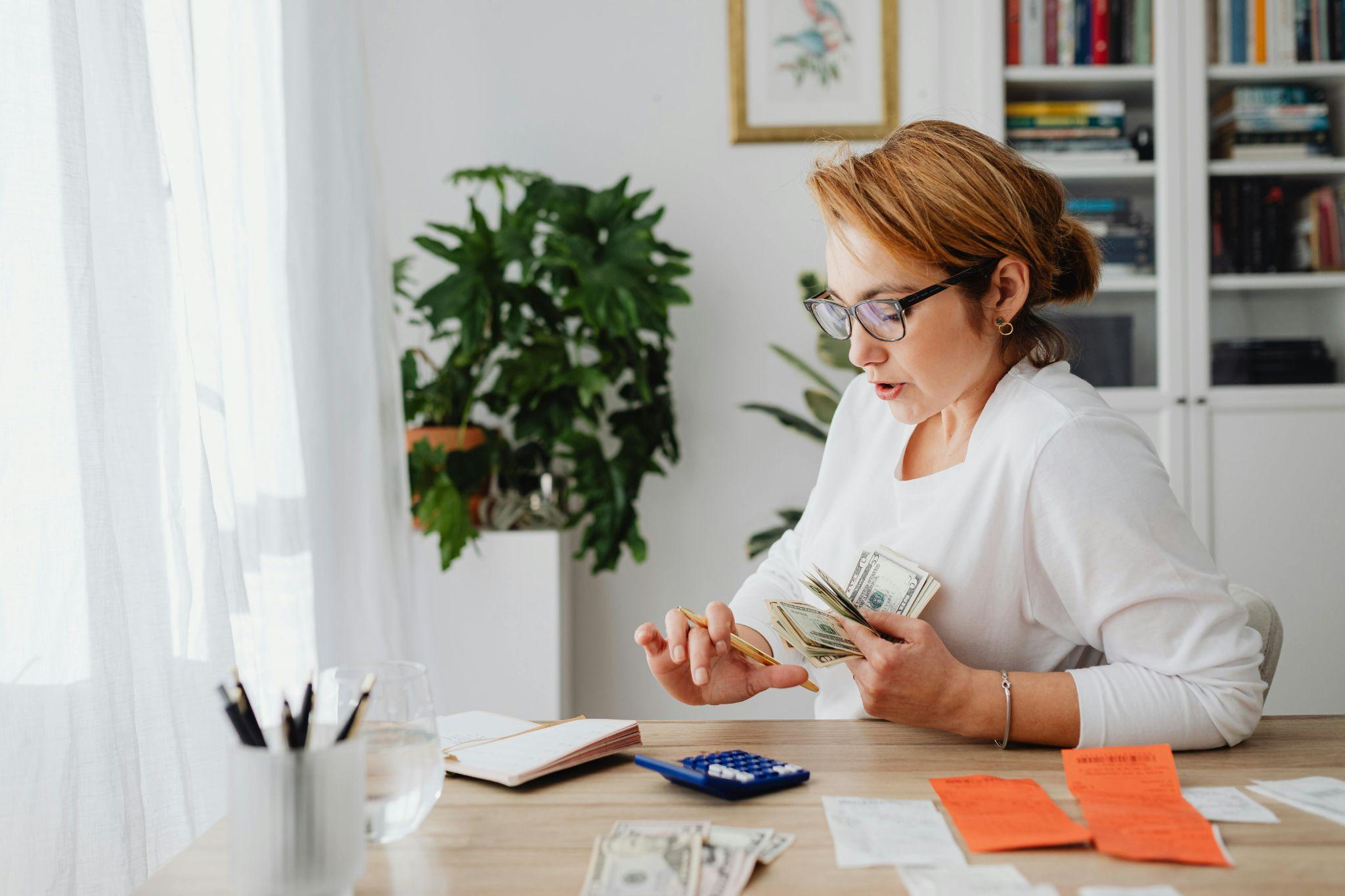 person counting money with calculator