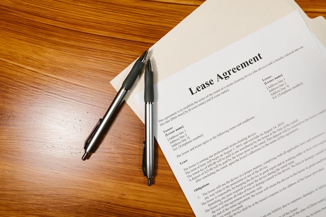 A lease agreement and two pens on a table