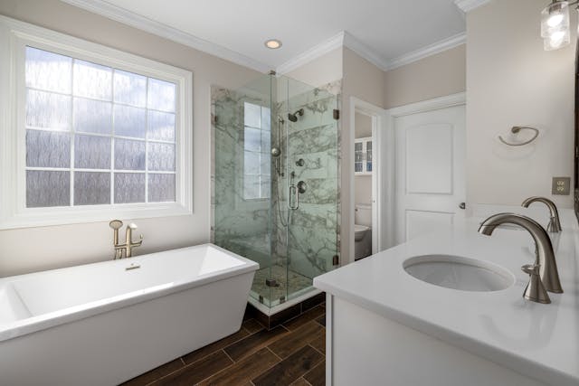 a-modern-bathroom-with-a-freestanding-bathtub-glass-enclosed-marble-shower-and-white-vanity