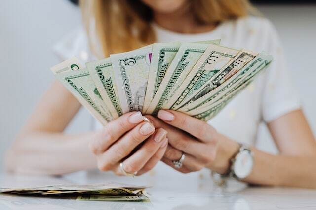 person-holding-dollar-bills-in-their-hands